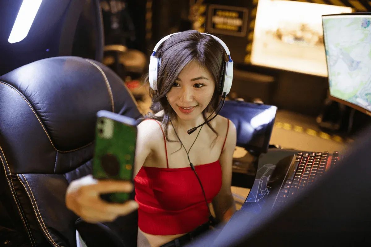Gamer in a red top and white headset filming herself at a lit rig