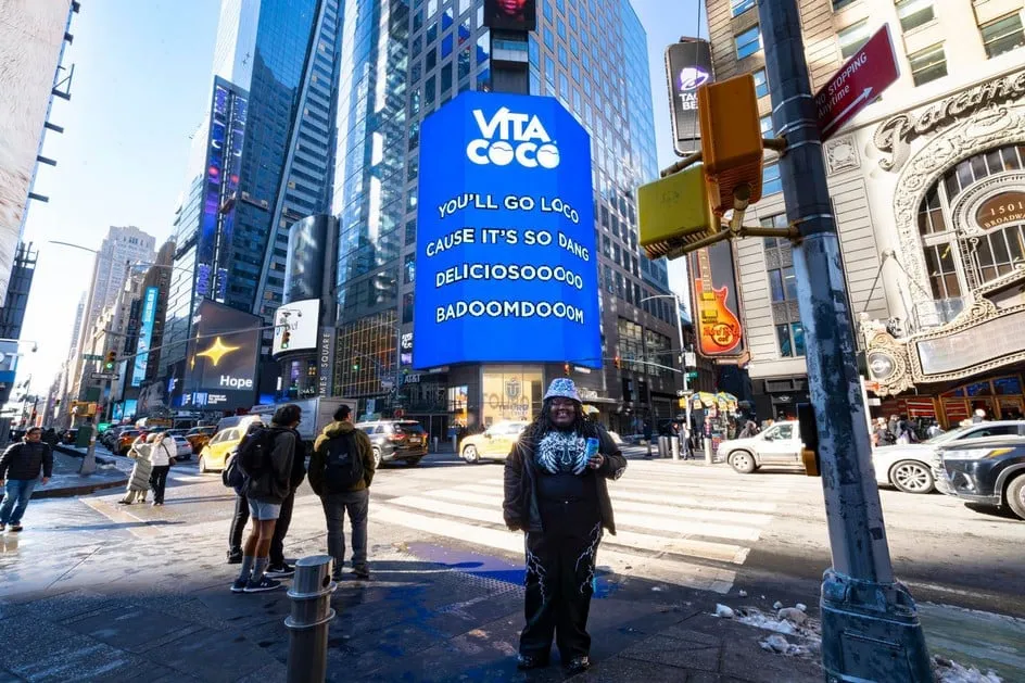 Romeo Bingham beneath the campaign billboard. Photo: CLIQSTREET MEDIA / Vita Coco.