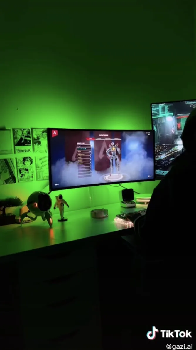 A TikTok still shows a gaming display and laptop in a green-lit desk setup.
