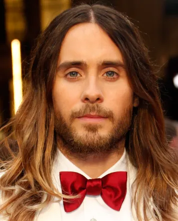 Jared Leto with long ombre hair and a red bow tie at a red carpet event