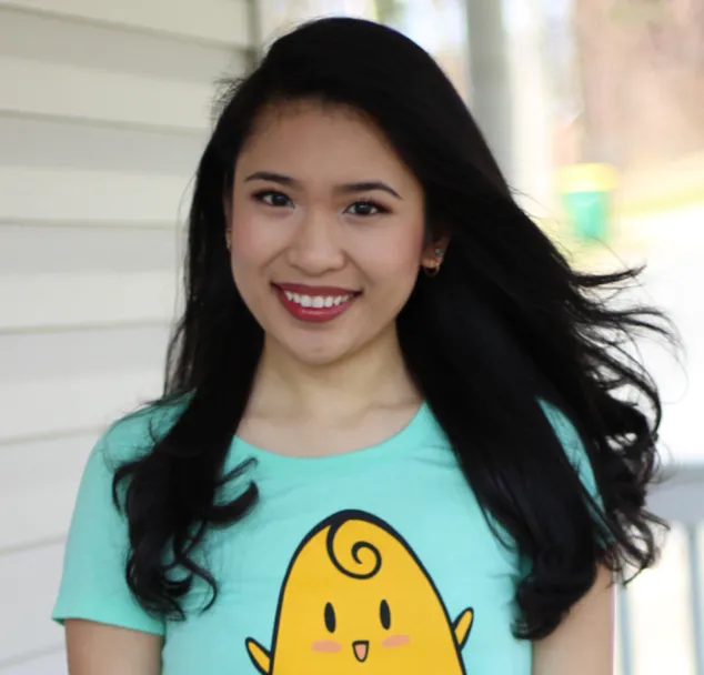 Smiling young woman with long dark hair in a mint green cartoon-print t-shirt