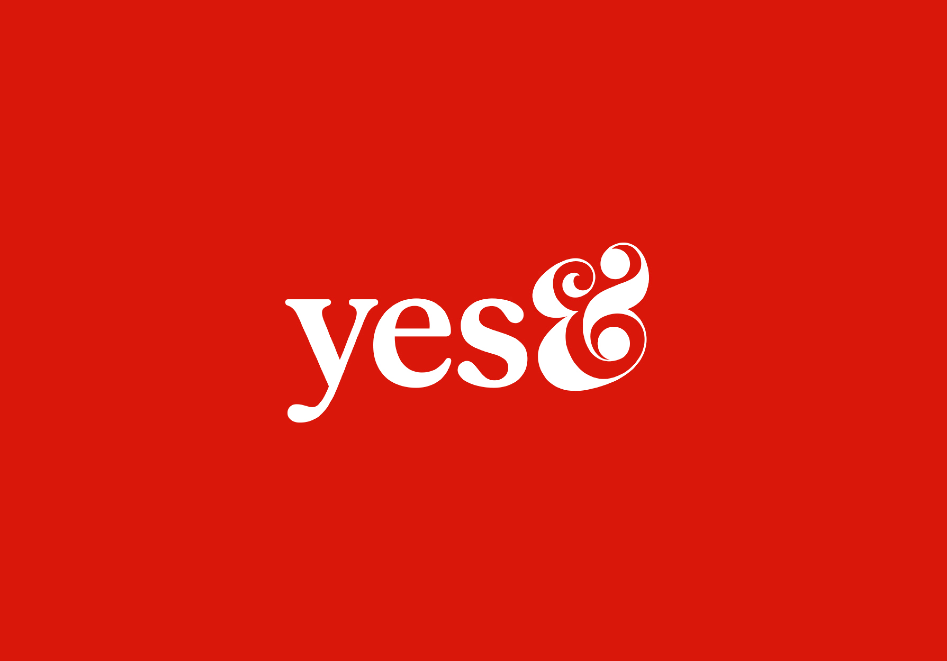 A minimalist graphic featuring the brand logo for "yes&" in a white, stylized serif font centered against a solid, vibrant red background. The ampersand is uniquely designed with elegant swirls, creating a modern and creative aesthetic for the agency's visual identity.